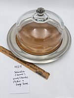 Platter with glass dome shown beside ruler for scale