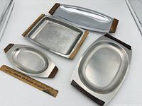 Group shot of all four stainless steel trays showing shapes and wood handles