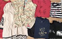 All six tops laid out to show variety, colours, graphics and overall condition