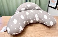Top view showing grey pillow with white cloud pattern and contoured shape