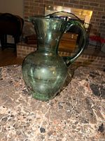 Full view of green glass pitcher on countertop