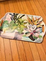 Full view of plastic tray showing succulent artwork and handles