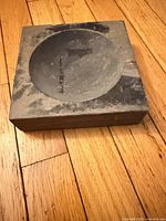 Top view of square ink stone showing circular basin and carved marks