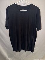 Front view of black alo T-shirt on hanger