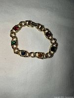 Front view showing gold-tone bracelet and six coloured stones