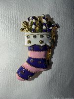Front view of stocking brooch showing enamel colours and details
