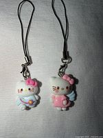 Front view of both Hello Kitty charms showing outfits and bows