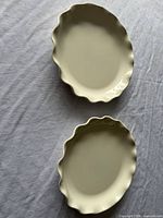 Two cream Pfaltzgraff scalloped plates top view
