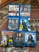 Seven Blu-ray movie cases laid out on rug