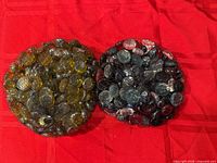 Two netted bags of assorted flat glass craft stones on red background
