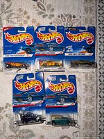 Front view of all five sealed Hot Wheels cars on cards