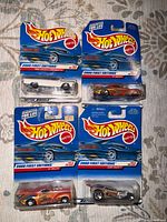 Front view of four sealed Hot Wheels 2000 First Editions blister cards