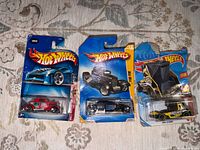 Front view of three sealed Hot Wheels cars on cards