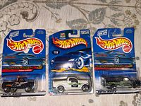 Front view of three sealed Hot Wheels Attack Pack Series cars on cards