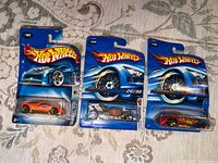 Front view of three sealed Hot Wheels blister cards