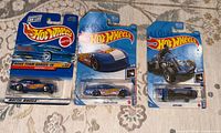 Front view of three sealed Hot Wheels cars in blister packaging