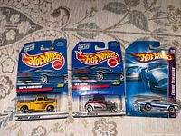 Front view of three sealed Hot Wheels cars showing models and packaging