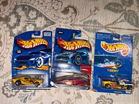 Front view of three Hot Wheels blister cards showing car models and numbers 186, 044 and T-Bucket