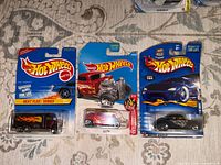 Front view of three sealed Hot Wheels cards showing vehicle designs