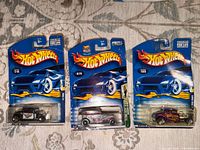 Front view of three sealed Hot Wheels cars showing models and numbers 216, 019, 195.