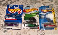 Front view of three sealed Hot Wheels cars showing models and colors.