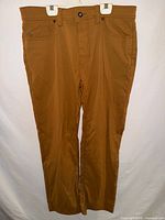 Front view of brown Prana slim fit pants on hanger