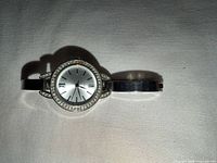 Front view of silver-tone ladies watch showing crystal bezel and dial