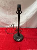 Full view of brown metal table lamp base with cord