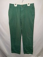 Full front view of green Vineyard Vines dress pants hanging