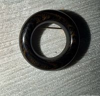 Front view of circular wooden brooch