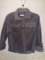 Front view of gray corduroy shirt on hanger