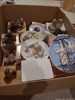 Overview of box showing boxed figurines and decorative plates
