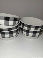Stacked view of five matching plaid bowls