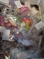 Multiple bagged plastic toy figurines inside box