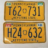 Front view of both license plates showing numbers, colors, stickers