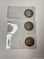 Three Barber half dollars in separate flips, full view