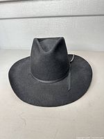 front angled view of black wool cowboy hat showing crown shape and hatband