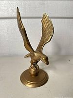 Front view of brass eagle figurine on round base