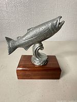 Front left view of silver-tone fish figurine on wood base