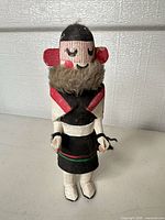 Front view of carved Kachina figure showing painted details and fur collar