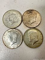 All four Kennedy Half Dollars obverse side visible