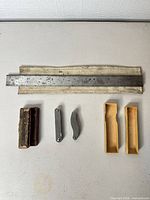 All items laid out: rule in sleeve, rectangular gauge block, two folding gauges, two cardboard cases