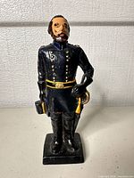 Front view of cast iron soldier figurine showing uniform details and paint wear