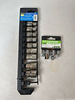 Full view of 10 sockets on rail beside sealed 4-pc adapter set