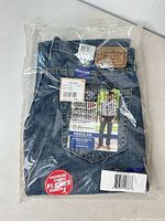Front view of packaged jeans showing size label and style information