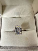 Top view of ring showing emerald-cut center stone and halo