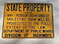 Front of yellow State Property traffic sign showing full text and color