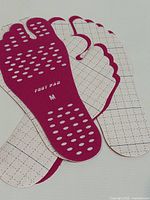 stacked view of pink stick-on soles showing tread pattern and peel backing
