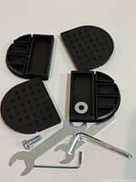 Overview of four pads, wrench, hex key, bolt and washer