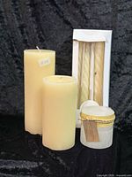 Group shot showing all candles: two pillars, boxed tapers, lidded candle
